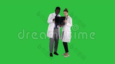 严肃善良的女医生和美国黑人医生在绿色屏幕上研究大脑x射线，Chroma键。
